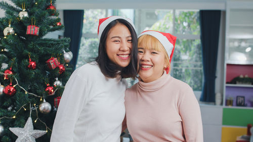 Portrait of happy young woman with christmas tree