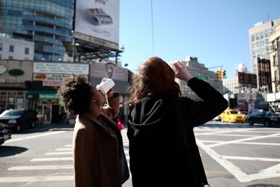 Rear view of woman photographing city street