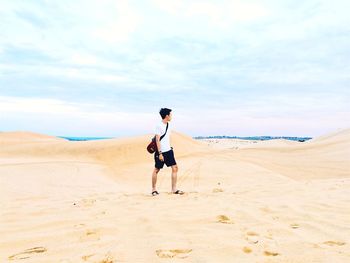 Full length of man walking on desert against sky