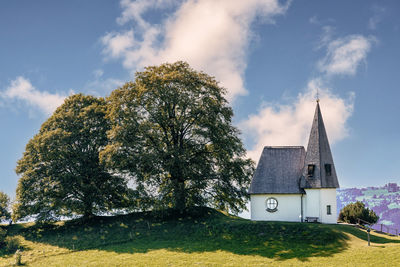 A small chapel against the blue sky with white clouds