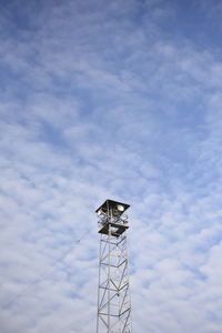Low angle view of communications tower against blue sky