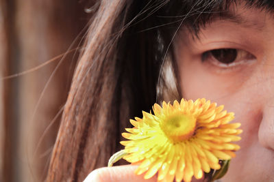 Close-up of woman holding yellow flower