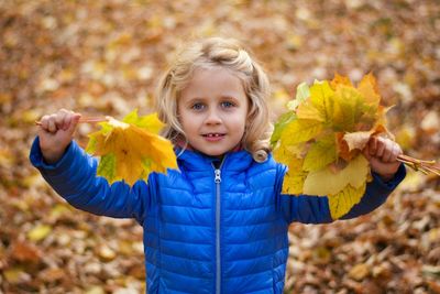 Portrait of smiling girl with autumn leaves