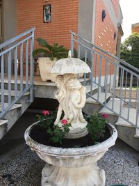 Statue of potted plant against building