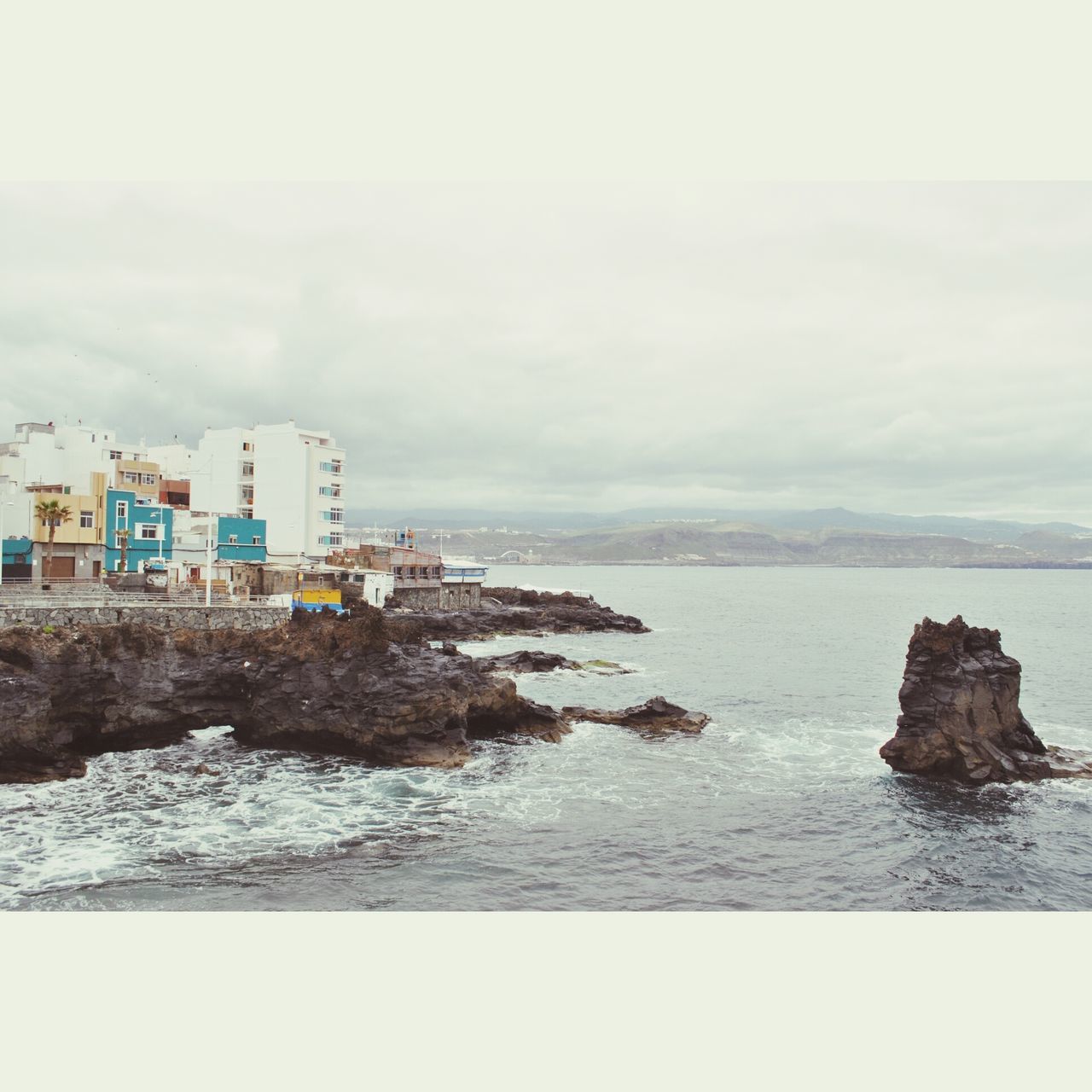 water, sky, sea, built structure, architecture, building exterior, cloud - sky, tranquil scene, rock - object, tranquility, waterfront, scenics, nature, beauty in nature, cloudy, cloud, auto post production filter, day, outdoors, overcast