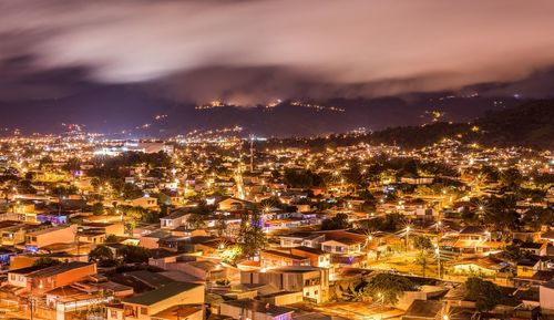 High angle view of illuminated cityscape against sky at night