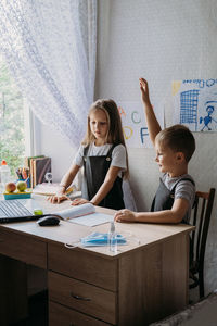 Cheerful sibling learning online at home