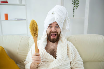 Portrait of man holding hat at home