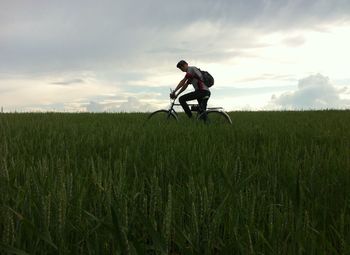 Man riding bicycle on grassy field