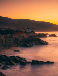 Scenic view of sea against orange sky