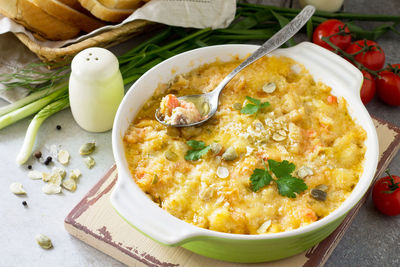 Casserole crumble with red fish, white bread and cheese on stone or slate background.