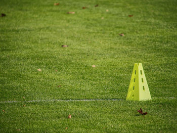 Yellow triangles used as soccer training equipment on green grass field