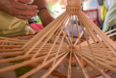 Craftsperson making paper umbrella with wood at workshop