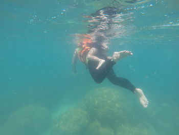 Boy swimming with mother in sea