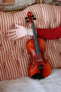 Low section of person with arms raised standing on bed