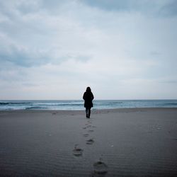 Rear view of a woman walking on beach