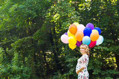 Low angle view of woman holding colorful balloons