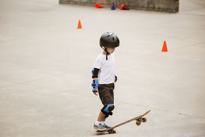 Boy standing with skateboard on ramp