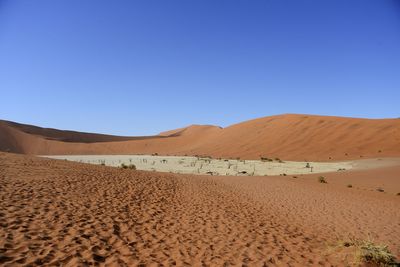 Scenic view of desert against clear blue sky