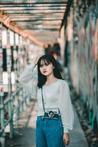 Young woman looking down while standing outdoors