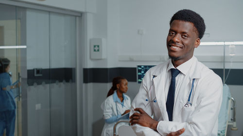 Confident doctor with arms crossed at hospital