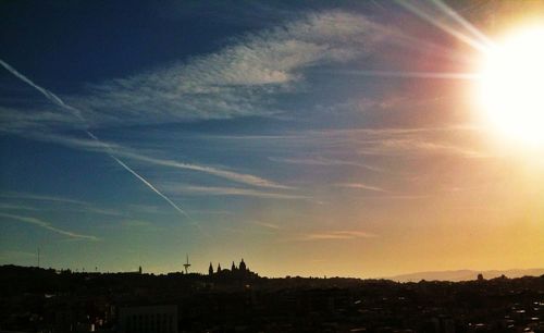 Sun shining through clouds over city