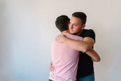 Two gay man hugging each other.