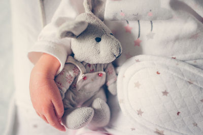 Newborn baby sleeps peacefully hugging soft toy. gentle a hand and a toy, at home, top view