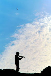 Low angle view of silhouette man standing against sky