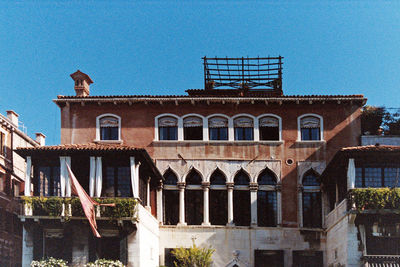 Low angle view of old building against clear blue sky