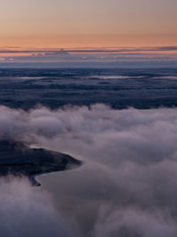 Scenic view of sea against dramatic sky during sunset