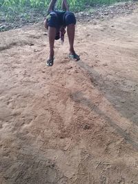 Low section of man skateboarding on sand