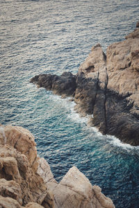 High angle view of rocks on sea shore