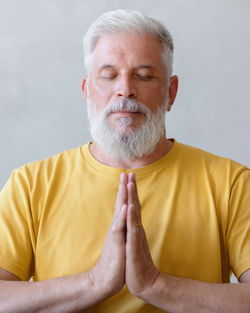 Mature man meditating at home