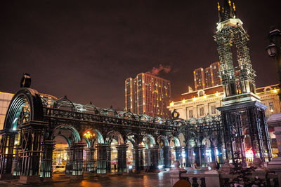 Illuminated buildings against sky at night