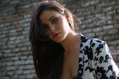 Close-up of young woman looking away against wall