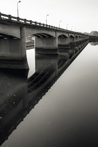 Reflection of bridge in lake against sky