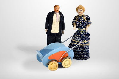 Rear view of man with toy standing against white background