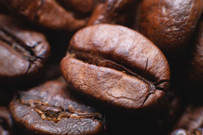 Close up extreme macro group of roasted brown or black coffee beans background in shallow depth of