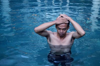 Portrait of shirtless man in swimming pool