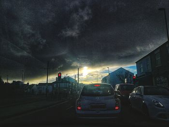 Cars on road in city at sunset