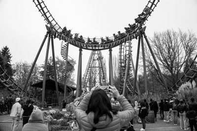 Rear view of woman standing against trees