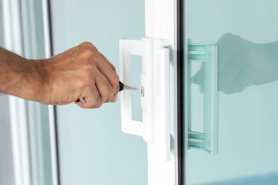 Cropped hand of man holding window