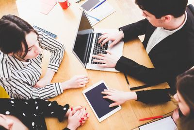 High angle view of people using laptop on table