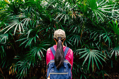 Woman wearing sunglasses standing against plants