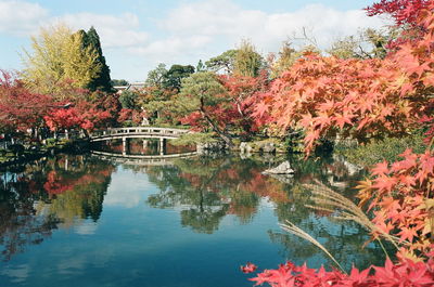 Arch bridge over lake against sky during autumn