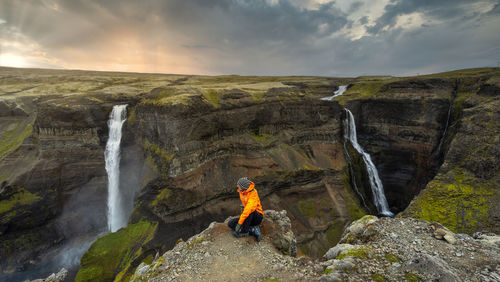 Man standing by rocks against sky