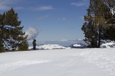 Man on snow covered landscape against sky