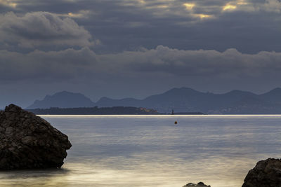 Scenic view of sea and mountains against sky