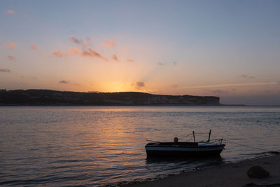 Fishing boats on a river sea at sunset in foz do arelho, portugal